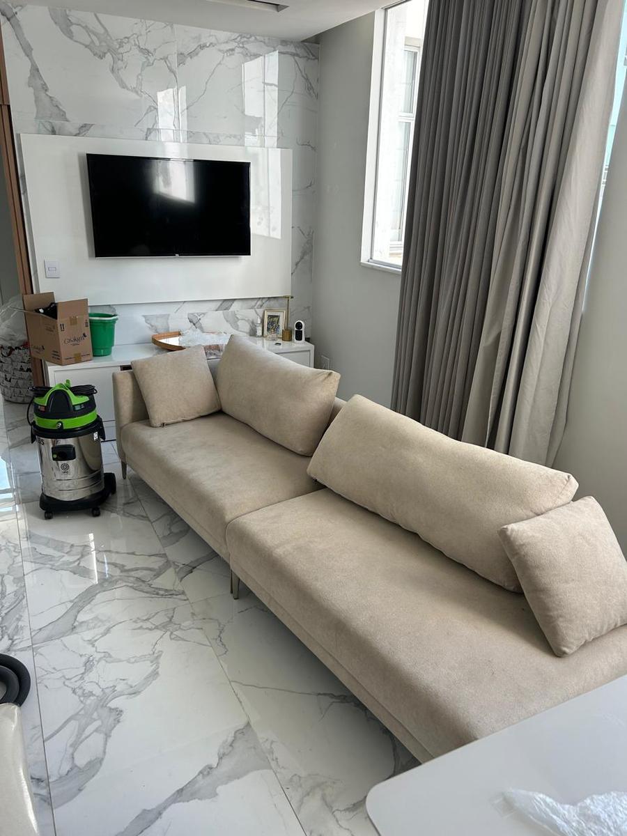Sofá de sala antes da higienização, com a extratora ao lado