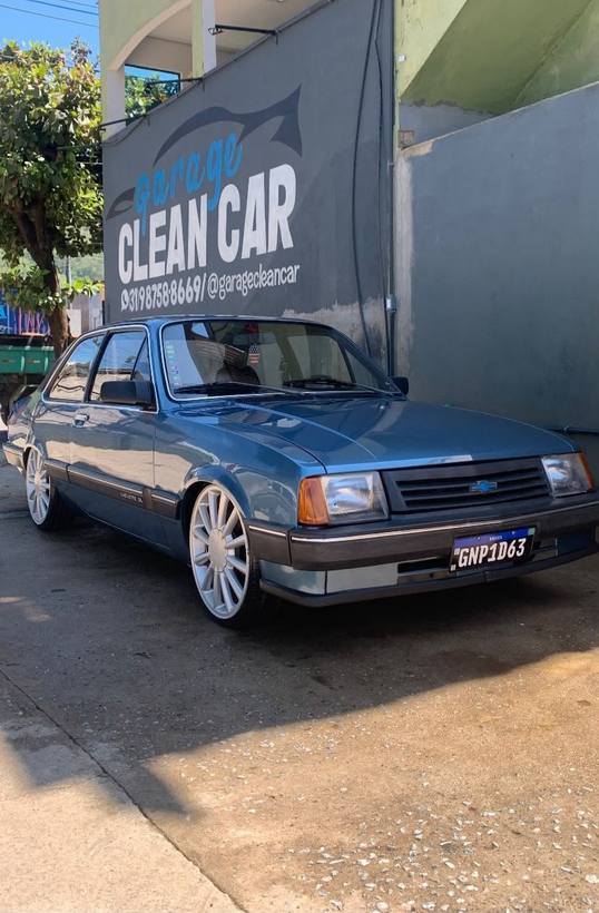 Opala Comodoro azul claro de três quartos em frente ao letreiro