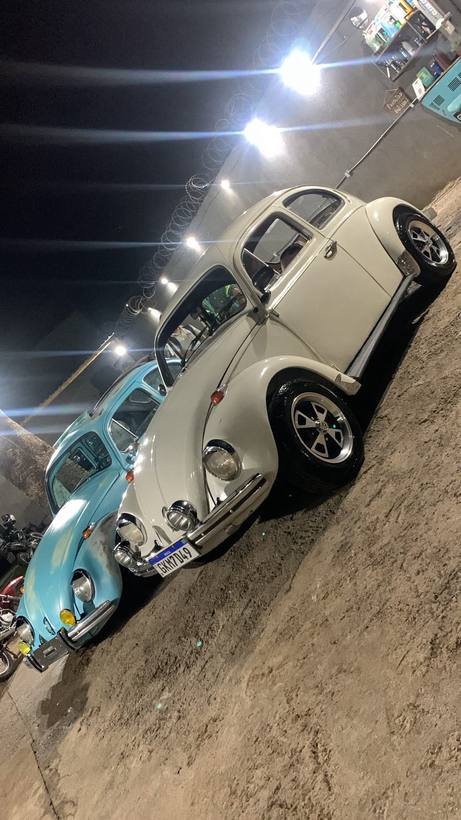 Dois Fuscas clássicos lado a lado à noite sob os refletores da Garage CleanCar