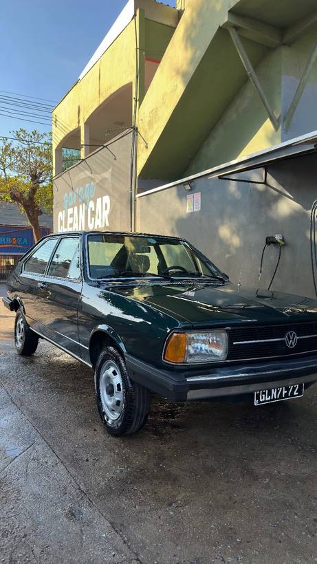 VW Passat verde escuro clássico em frente ao letreiro