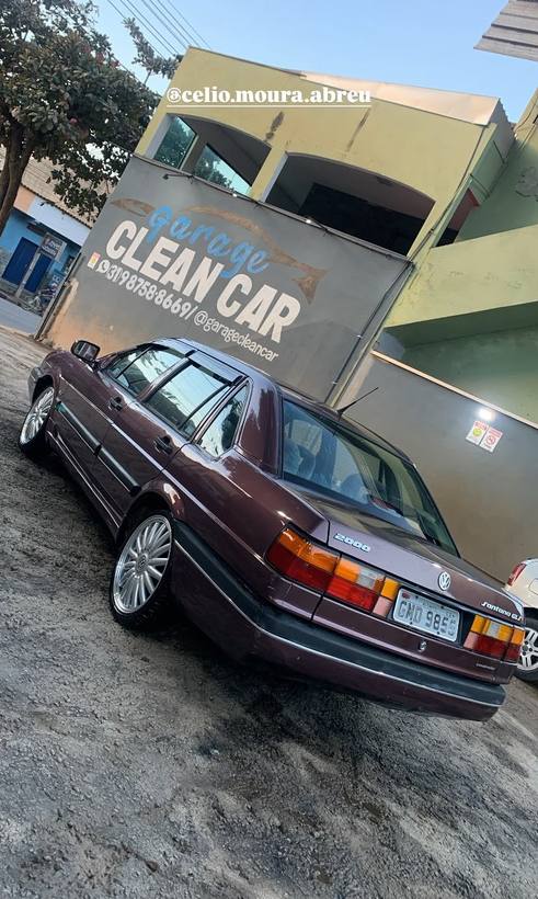 VW Santana GL vinho rebaixado com rodas aro grande em frente ao letreiro
