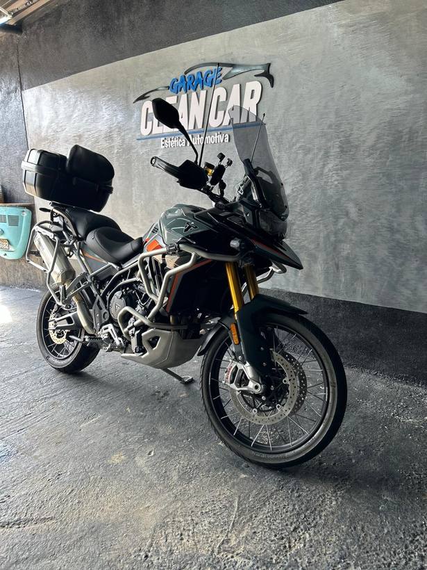 Triumph Tiger preta em frente ao letreiro da Garage CleanCar